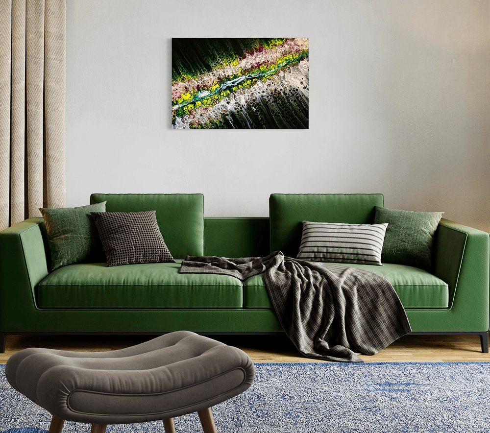 Green sofa with pillows and wall art.